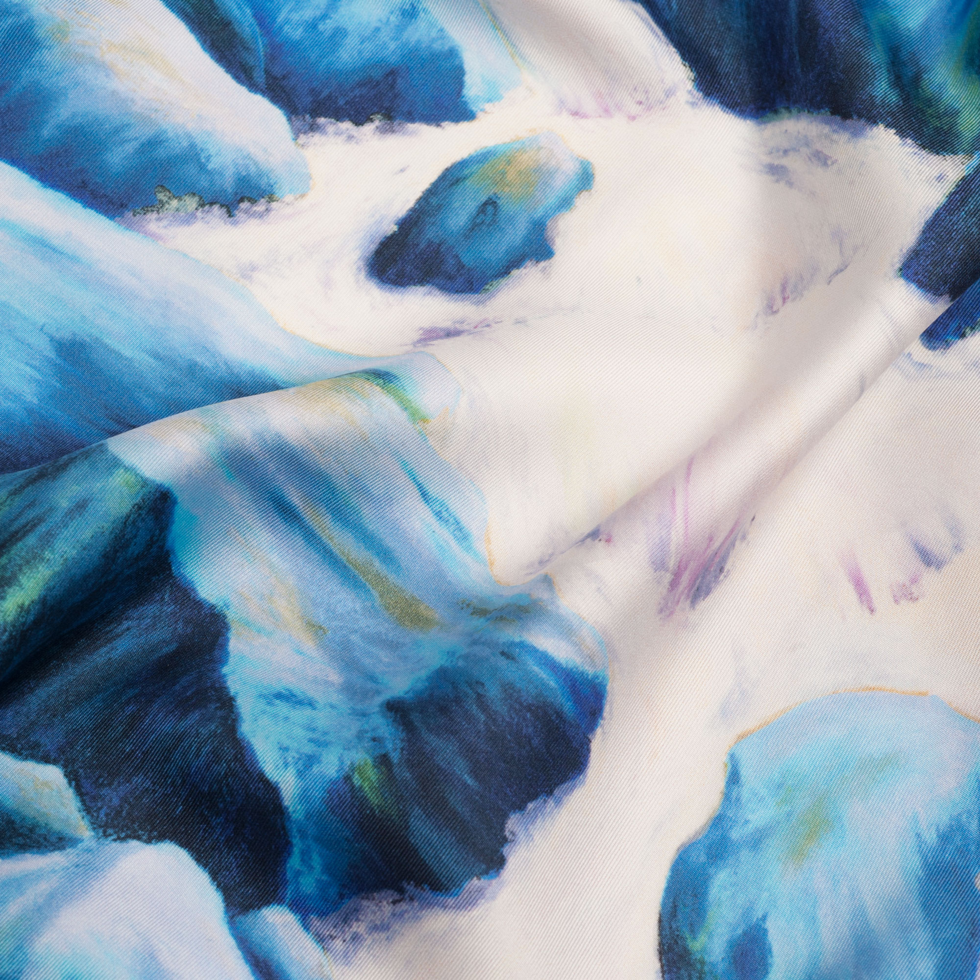 Gros plan sur foulard en soie blanc et bleu électrique motif eau qui coule et rochers