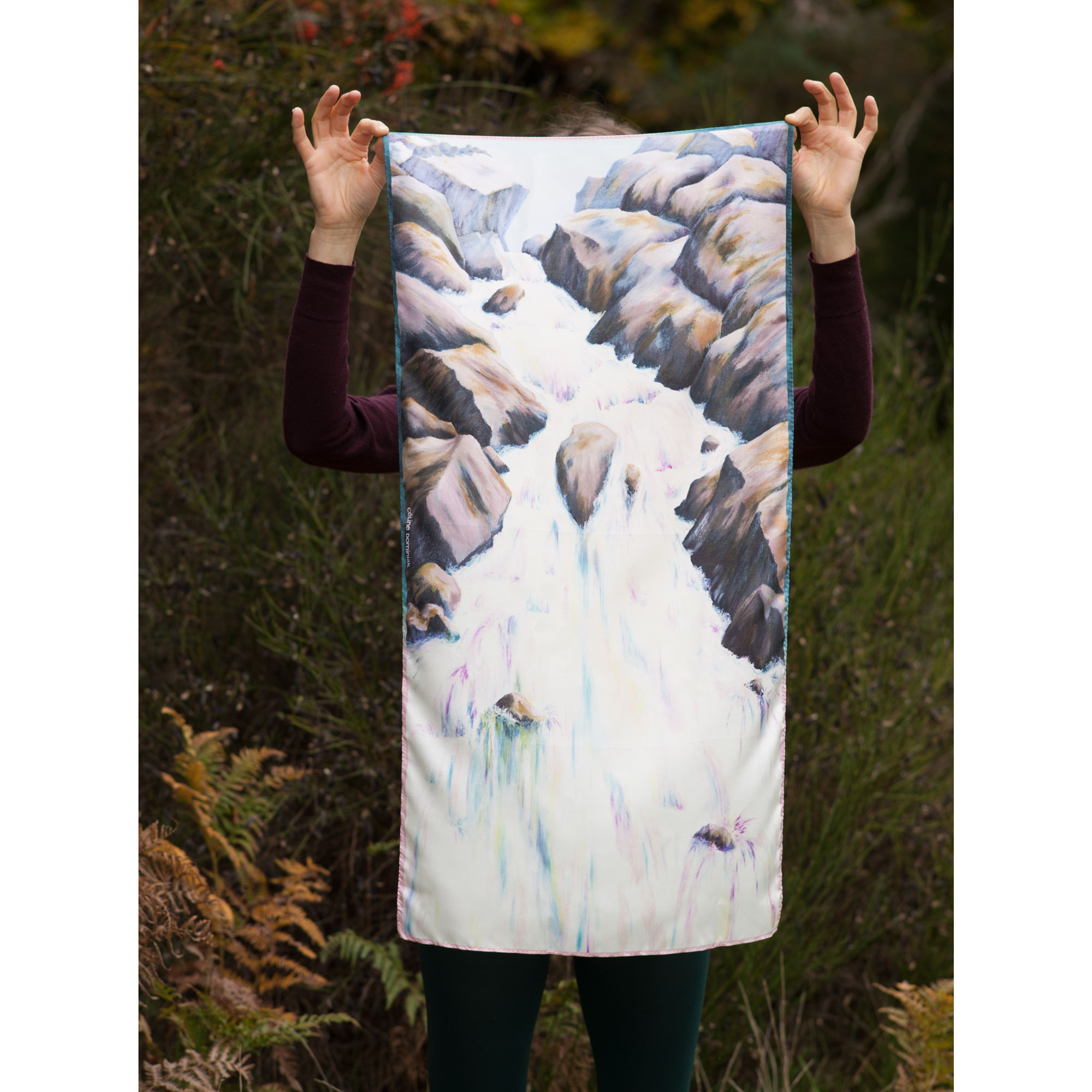 Foulard en soie motif Cascade coloris Minéral tenu devant paysage automne