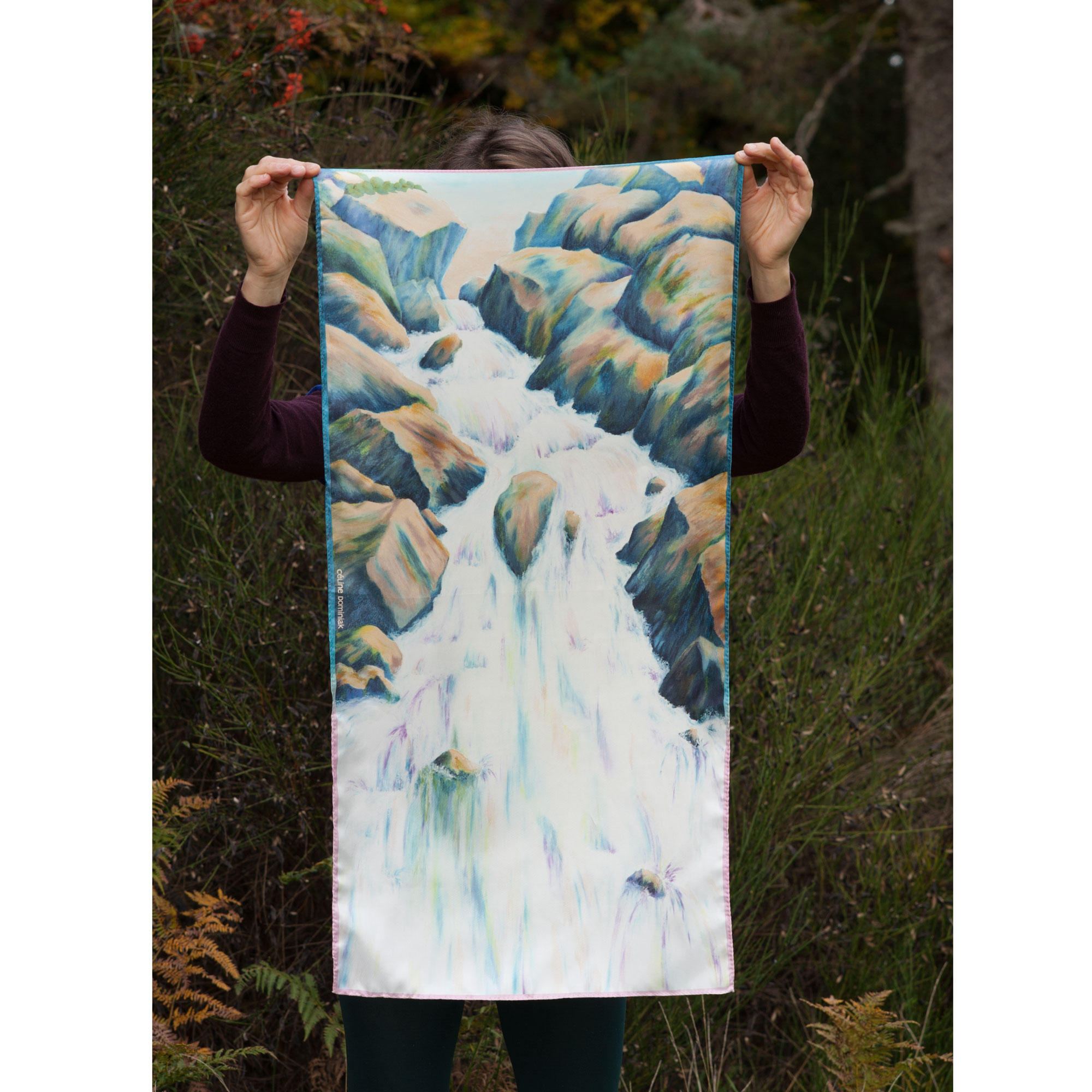 Foulard en soie motif Cascade coloris Mousse tenu devant paysage automne